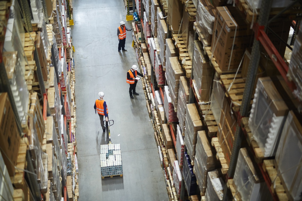 looking down into a warehouse with employees working in logistics management in ecommerce