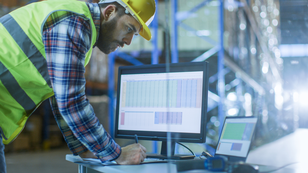 Employee working on computers for supply chain automation